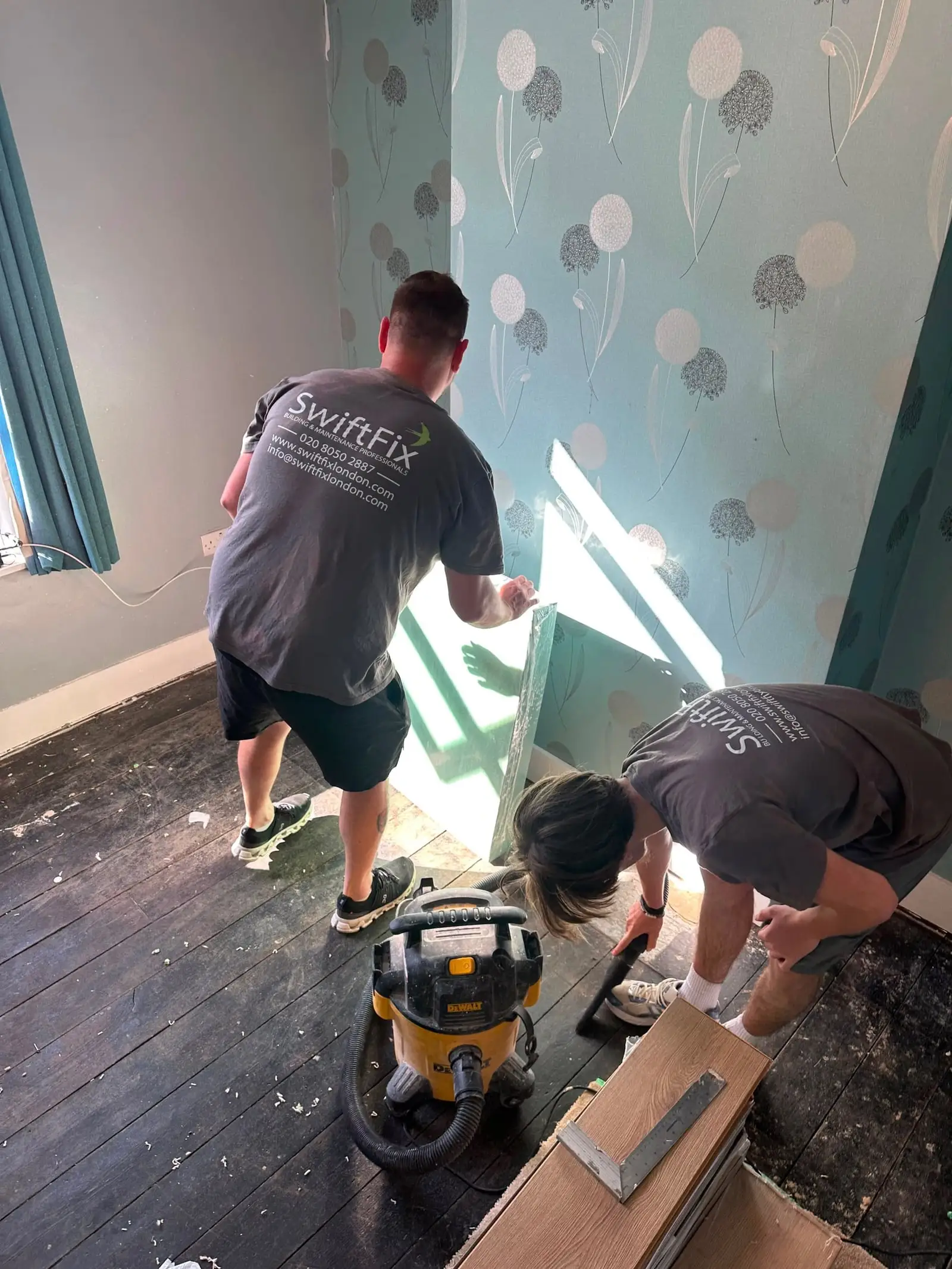 Two Swift Fix team members stripping a bedroom back to bare walls