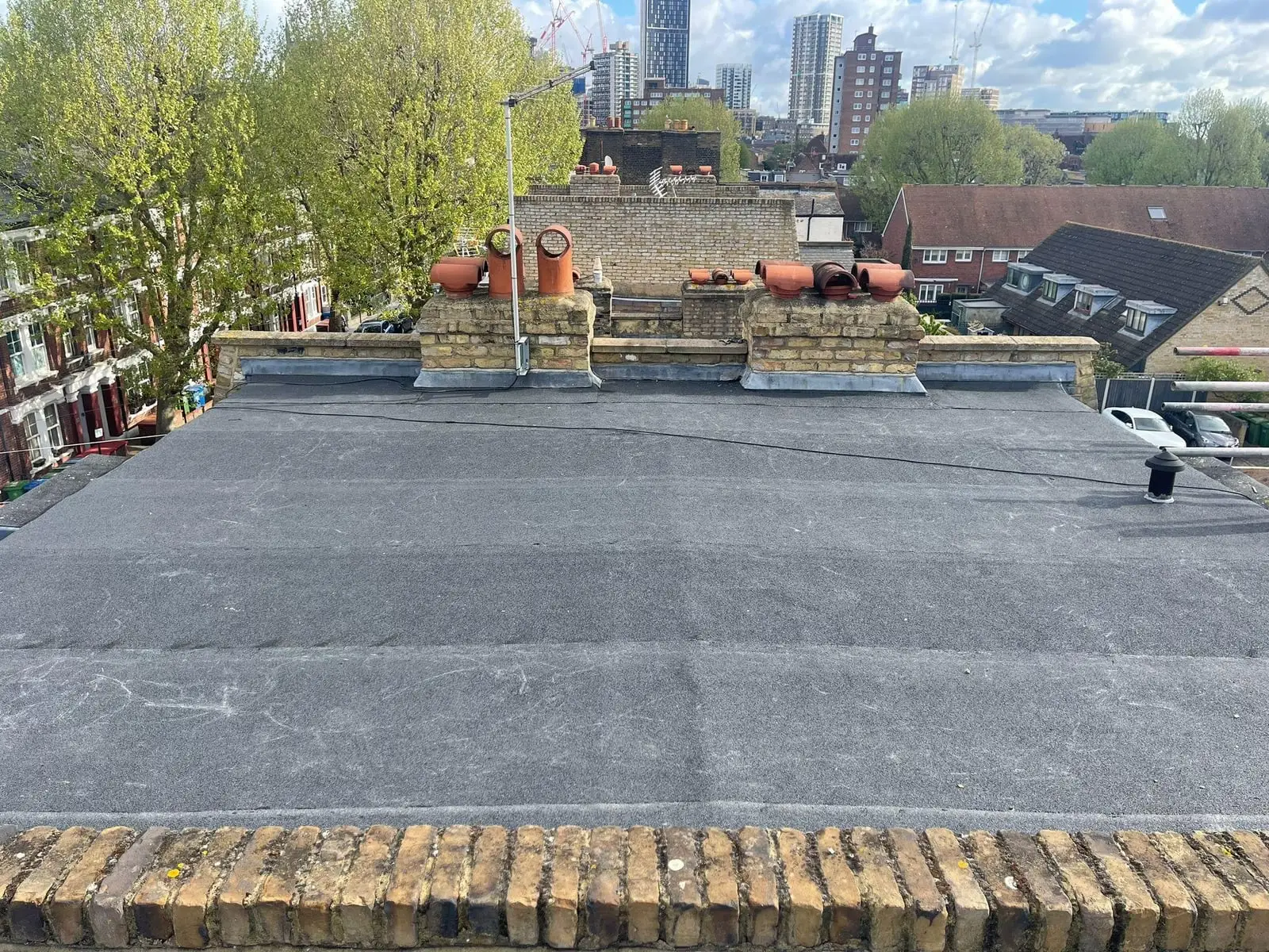 Flat roof with rubber membrane and London skyline behind