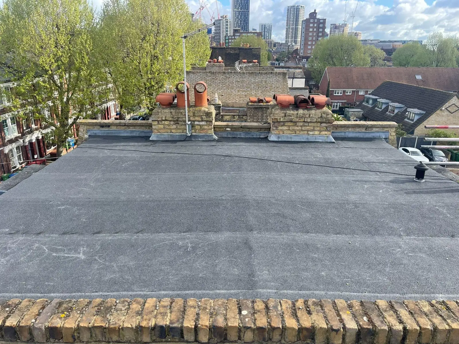 Newly covered flat roof with a rubber membrane and the London skyline beyond