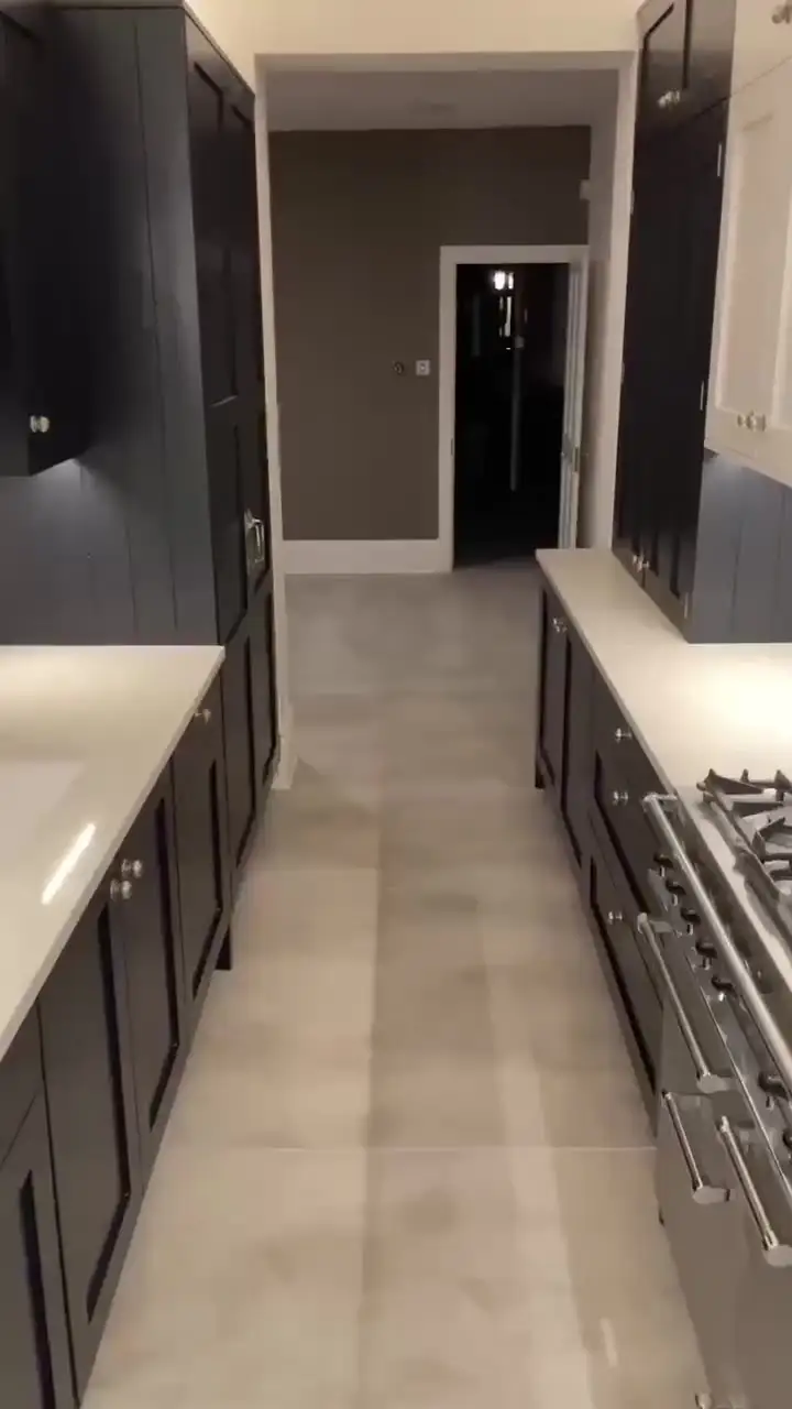Dark shaker galley kitchen with pale porcelain floor