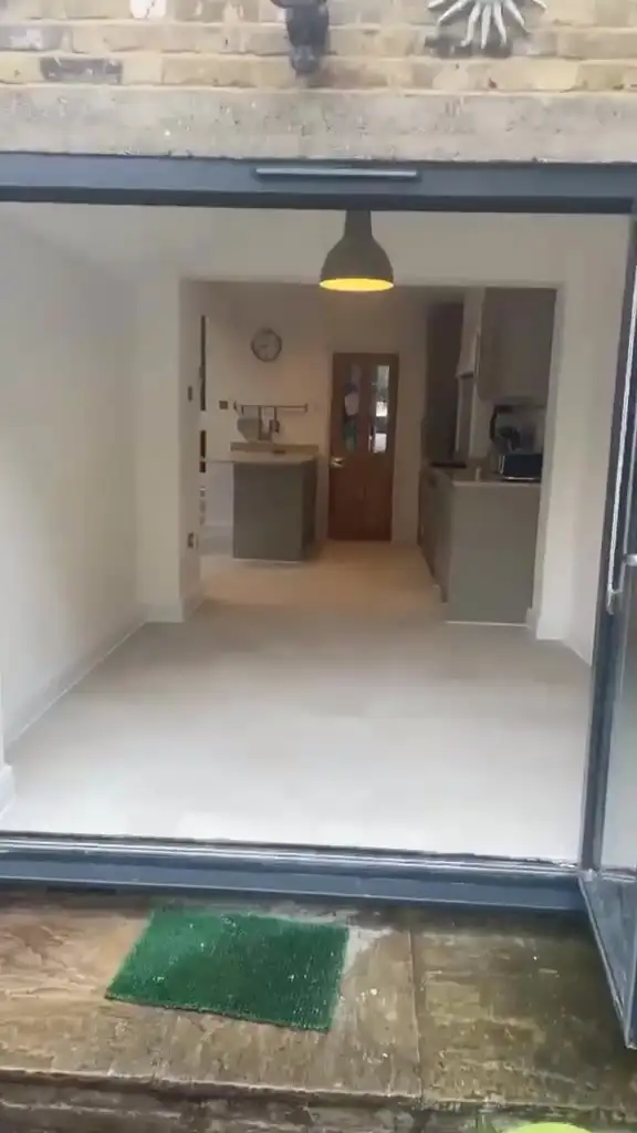 Kitchen extension with bifold doors and new large-format pale porcelain floor tiles