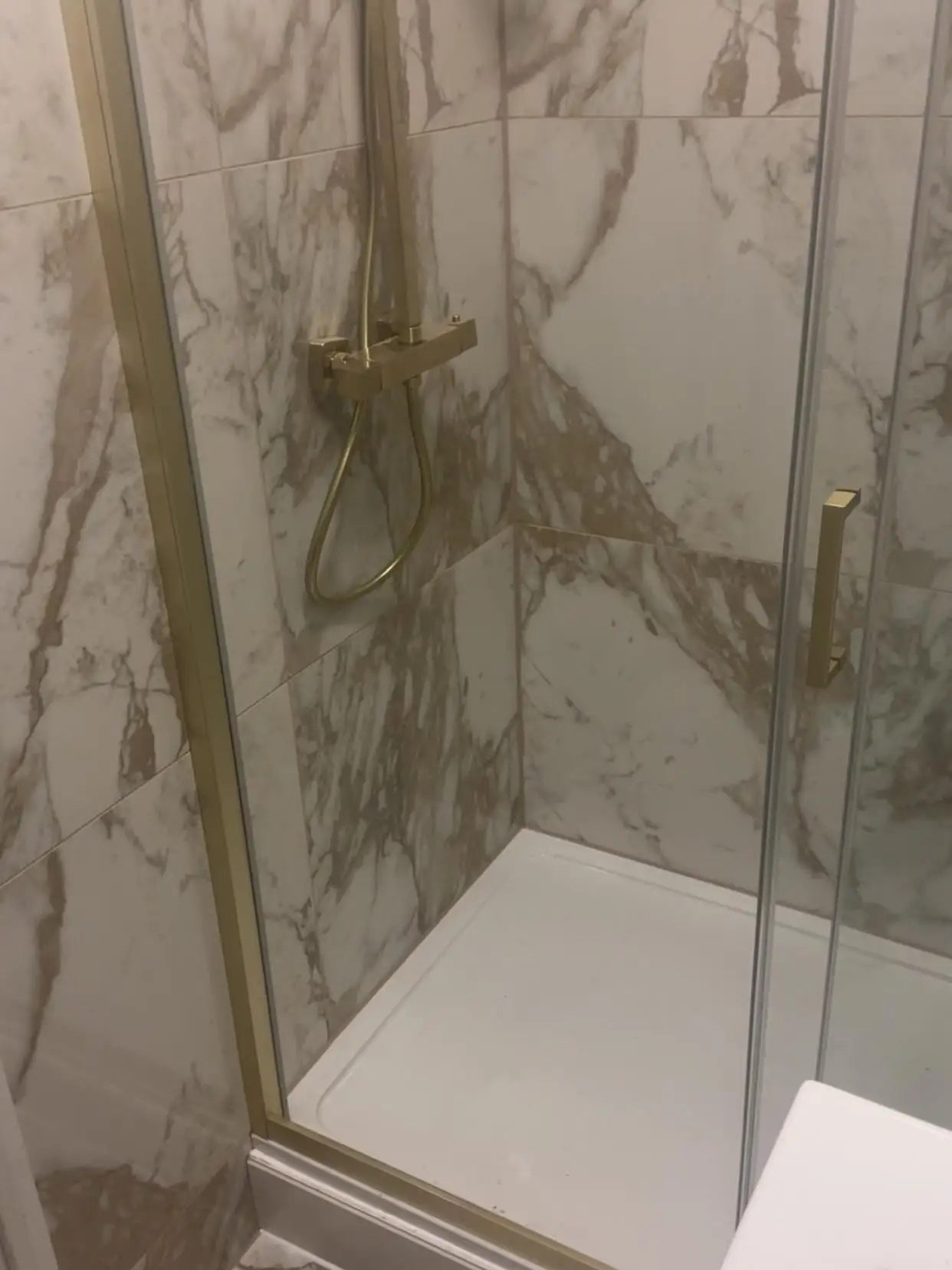 Walk-in shower tray and glass screen in marble-effect bathroom