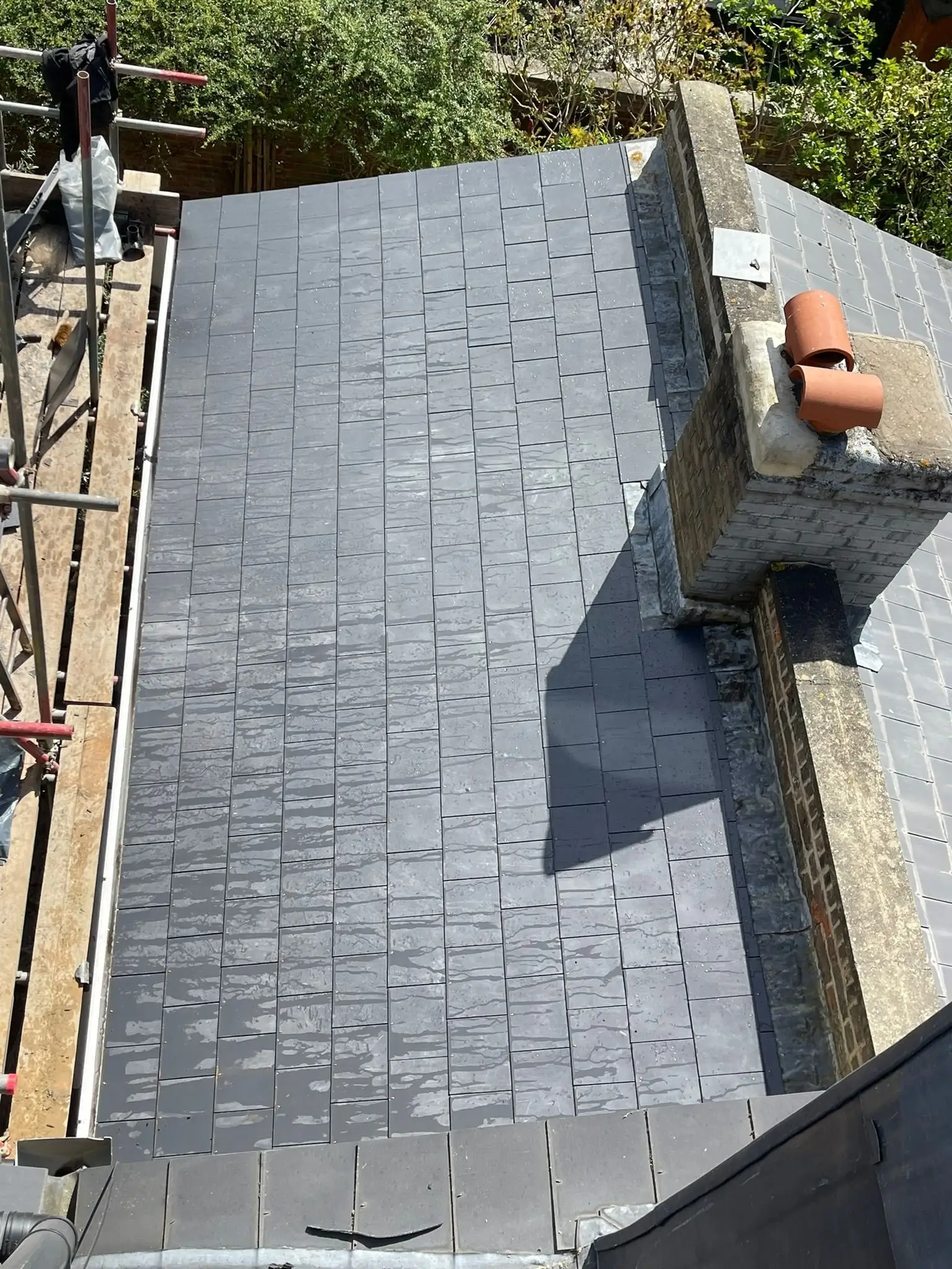 Slate roof detailed around a chimney stack