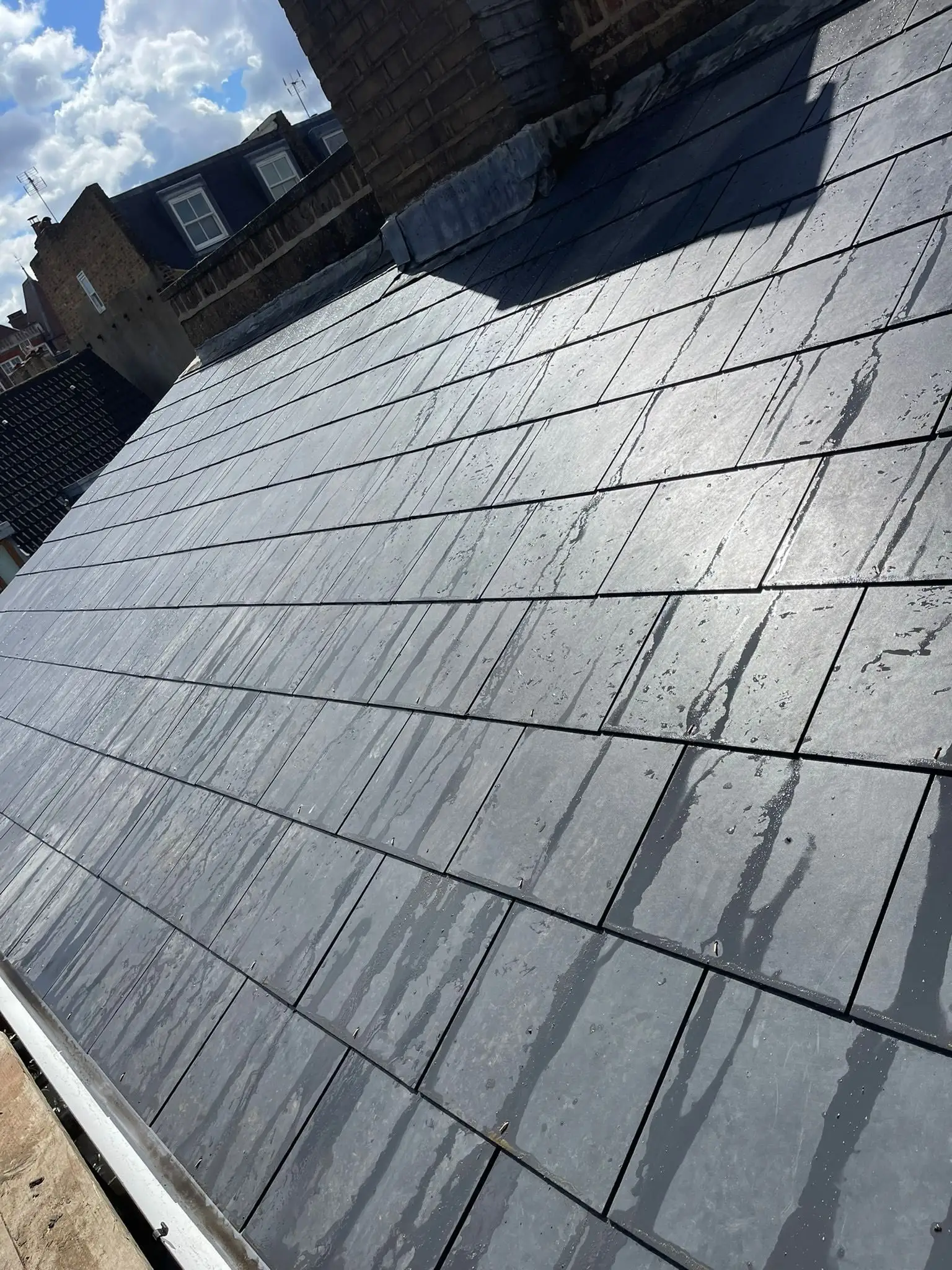 Newly slated roof slope on a London terrace, looking across neighbouring rooftops