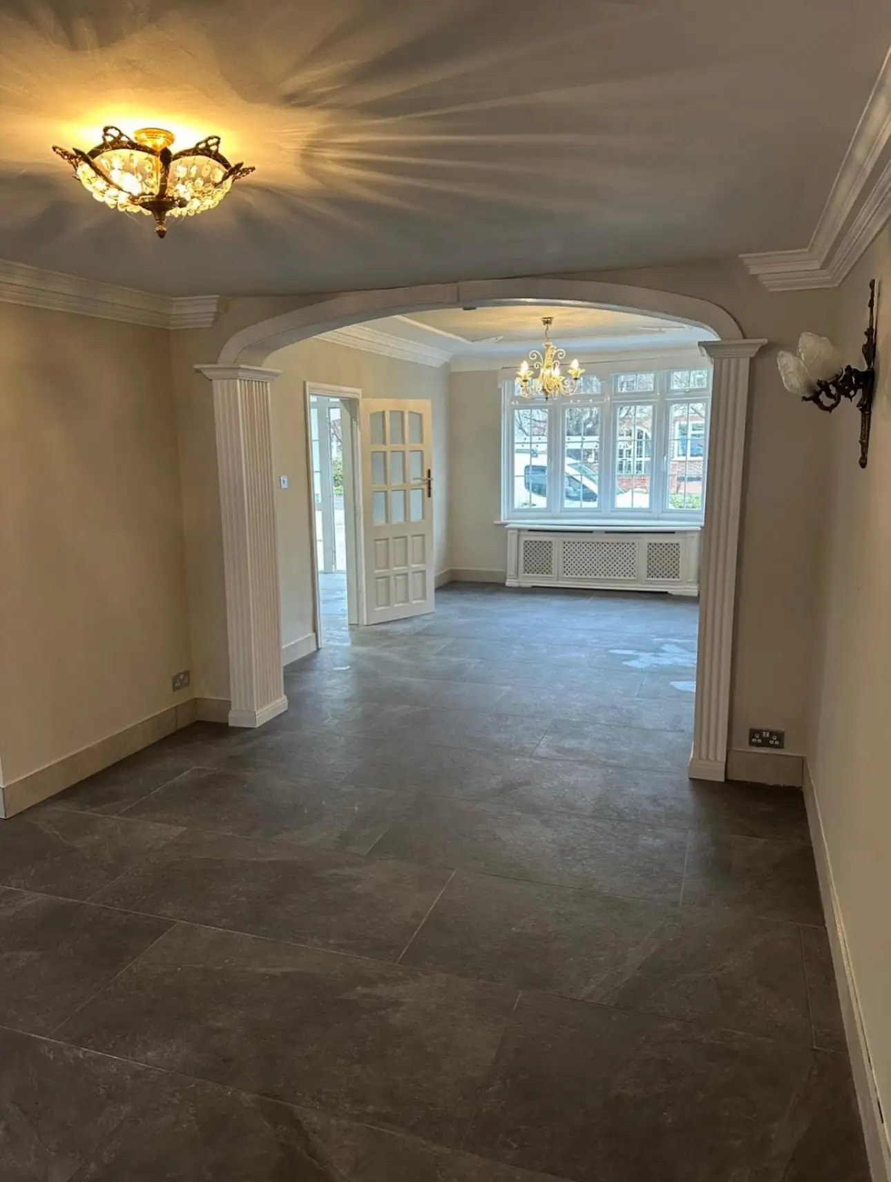 Freshly plastered and decorated reception rooms with arched opening and chandeliers