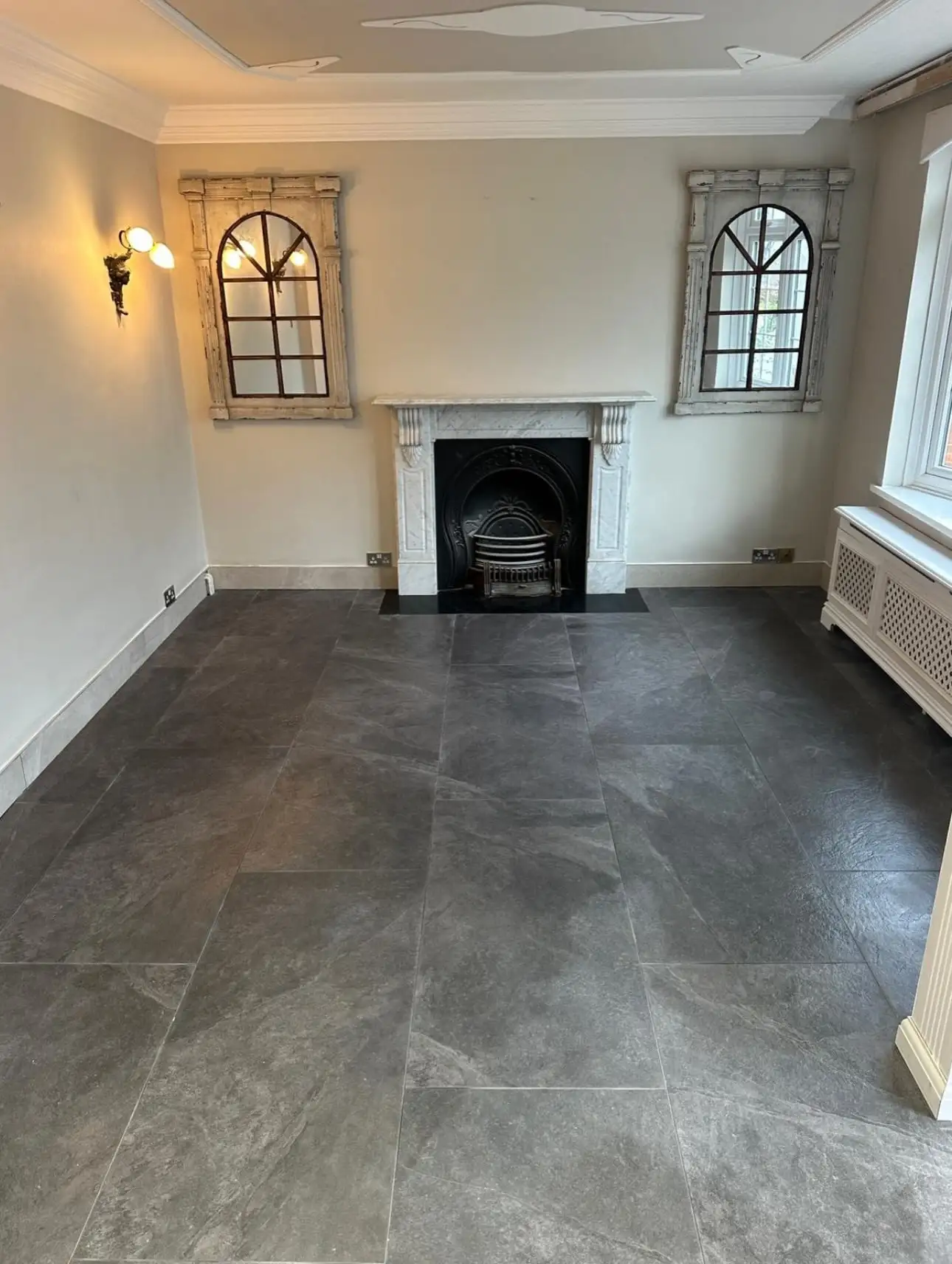 Reception room fully refurbished after water damage, with new tiled floor and decoration